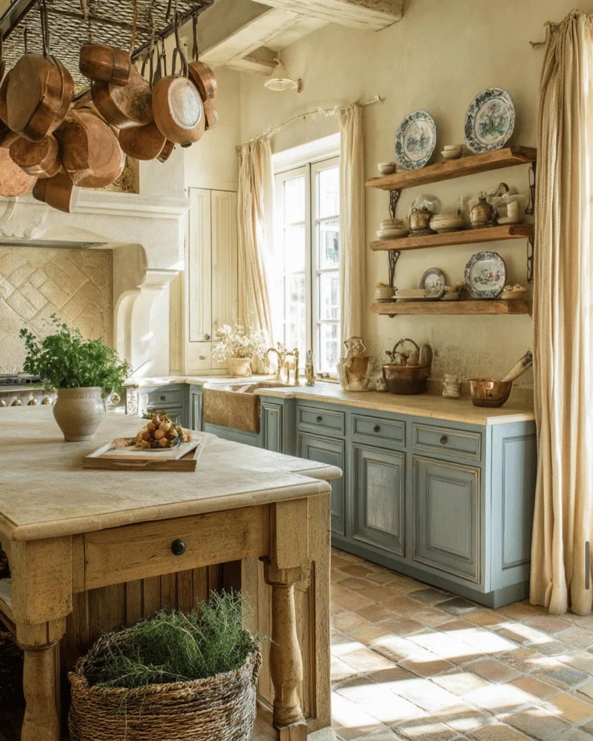 Wooden kitchen island in a rustic French farmhouse kitchen with blue-grey cabinetry.